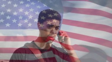 Amerika Birleşik Devletleri bayrağı üzerine telefonda beyaz bir adamın animasyonu. Amerikan vatanseverliği, bağımsızlık, gelenek ve dijital olarak üretilen video konsepti.