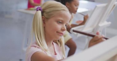 Sanat sınıfında resim yapan beyaz kız öğrenci yerine çok renkli yaratıcı metnin animasyonu. Yaratıcılık, okul, eğitim, çocukluk ve öğrenme, dijital olarak oluşturulmuş video.