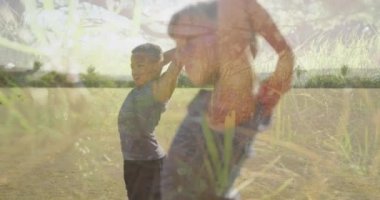 Açık hava fitness sınıfında egzersiz yapan çocuklar üzerinde güneş ışığı ve ağaçların animasyonu. Spor, sağlık, okul, eğitim, çocukluk ve öğrenme, dijital olarak üretilen video.