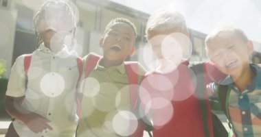 Bokeh ışıklarının animasyonu okul dışında birlikte yürüyen mutlu okul çocuklarının üzerinde. Arkadaşlık, okul, eğitim, çocukluk ve öğrenme, dijital olarak oluşturulmuş video.