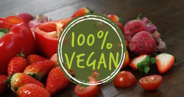 新鮮な赤果物や野菜の上にビーガンテキストのアニメーション ビーガン食 新鮮な果物や野菜のコンセプトデジタル生成されたビデオ — ストック動画