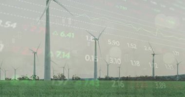Gri gökyüzüne karşı çayırlarda dönen yel değirmenlerinin üzerinde işlenen borsa verilerinin animasyonu. Küresel ekonomi ve yenilenebilir enerji teknolojisi kavramı
