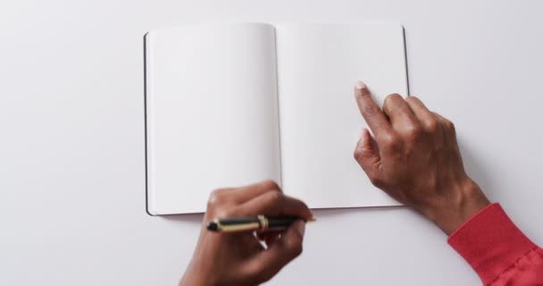 遅い動きの白い背景のコピースペースが付いている本のペンで手の執筆の終わり — ストック動画