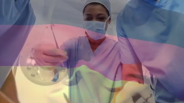 病院で手術を行う外科医のチームに対してドイツ国旗を振るアニメーション 国立医療技術構想 — ストック動画