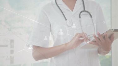 Tablet kullanan beyaz kadın doktor üzerindeki ikonlarla bağlantı ağının animasyonu. Küresel iş, tıp ve dijital arayüz kavramı, dijital olarak üretilen video.