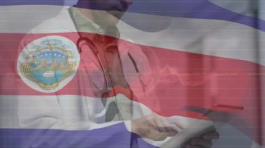 Hastanede dijital tablet kullanan beyaz erkek doktorun Costa rica bayrağını dalgalandırması. Dijital bileşik, çoklu pozlama, tıbbi, sağlık, özgürlük ve vatanseverlik kavramı.