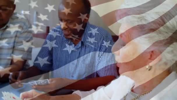 Animacja Machająca Flagą Ameryki Nad Starszymi Przyjaciółmi Grającymi Karty Domu — Wideo stockowe