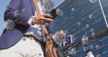 Açık havada akıllı telefon kullanarak Asyalı bir adamın yüz maskesi takıp bisiklet kullandığı Coperid 19 hücrelerinin animasyonu. Coronavirus covid-19 salgın konsepti