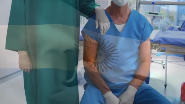Animering Vinka Argentina Flagga Mot Kaukasiska Manliga Och Kvinnliga Kirurger — Stockvideo