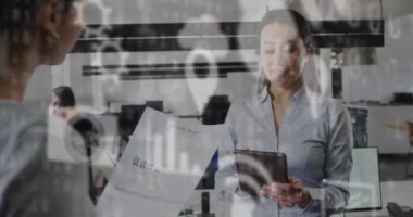 Ofisteki iki ırklı iş kadınıyla ilgili veri işleme animasyonu. Küresel iş, bağlantılar, dijital arayüz, hesaplama ve veri işleme kavramı dijital olarak oluşturuldu.