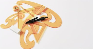 Pusula, kalem, silgi, silgi ve cetveller beyaz arka planda kopya alanı, yavaş çekim. Geometri, tasarım, öğrenme ve eğitim kavramı.