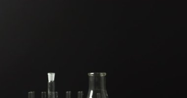 Test tüpleriyle renkli sıvılar fotokopi alanı olan siyah arka planda duruyor, yavaş çekim. Bilim, kimya, öğrenme, araştırma, laboratuvar, okul ve eğitim kavramı.