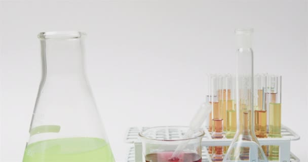 彩色液体装在瓶中 试管在白色背景上 慢动作 实验室 学校和教育概念 — 图库视频影像