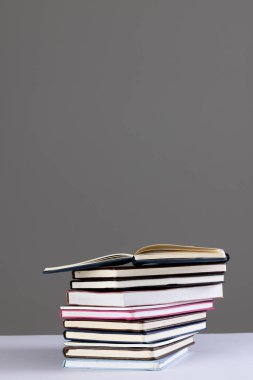 Gri arkaplanda kopya alanı olan kitap ve defterleri kapat. Okuma, öğrenme, okul ve eğitim kavramı.