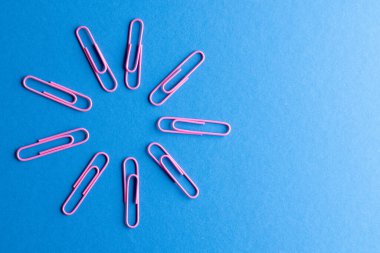 Pembe ataçları daire içine al ve mavi arkaplana uzayı kopyala. Okul malzemeleri, organizasyon, öğrenme, okul ve eğitim kavramı.