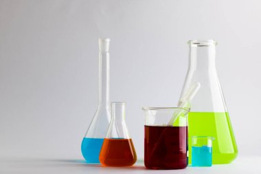 Beyaz arka planda fotokopi alanı olan kimya test tüplerini ve çanakları kapatın. Bilim, kimya, öğrenme, okul ve eğitim kavramı.