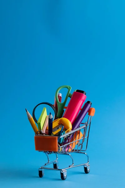 Nahaufnahme Eines Miniatur Einkaufswagens Mit Schulmaterialien Und Kopierraum Auf Blauem — Stockfoto