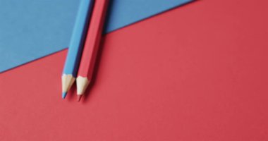 Mavi ve kırmızı renkli pastel boyaları kırmızı ve mavi arka planda yavaş çekimde kopyala. Kırtasiye, öğrenim, okul ve eğitim kavramı.