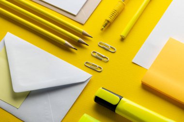 Sarı kalemler, fosforlu kalemler, fosforlu kalemler ve sarı zemin üzerinde kopya alanı olan beyaz kağıtlar. Okul malzemeleri, yazma, renklendirme, çizim, öğrenme, okul ve eğitim kavramı.
