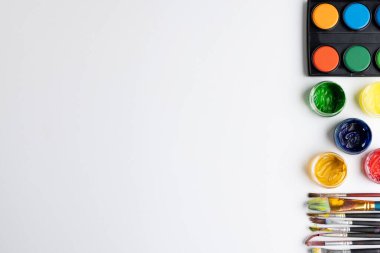 Beyaz arkaplanda fotokopi alanı olan boya ve fırçaları kapat. Okula dönüş, sanat, resim, okul malzemeleri, öğrenme, okul ve eğitim kavramı.