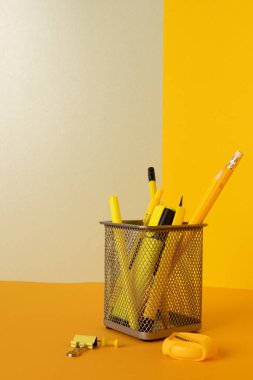 Sarı kalemli konteynırı kapat ve sarı arka planda kopya alanı olan kalemleri kapat. Okul malzemeleri, yazma, renklendirme, çizim, öğrenme, okul ve eğitim kavramı.