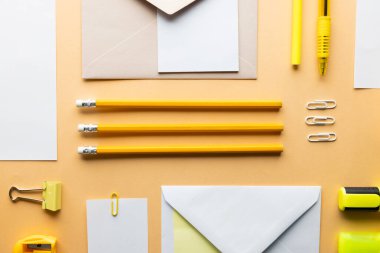 Sarı kalemler, fosforlu kalemler, fosforlu kalemler ve sarı zemin üzerinde kopya alanı olan beyaz kağıtlar. Okul malzemeleri, yazma, renklendirme, çizim, öğrenme, okul ve eğitim kavramı.