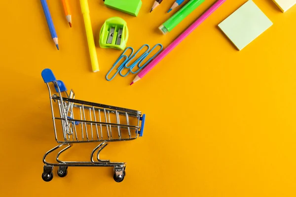 Nahaufnahme Eines Miniatur Einkaufswagens Mit Schulmaterialien Kopierraum Auf Orangefarbenem Hintergrund — Stockfoto