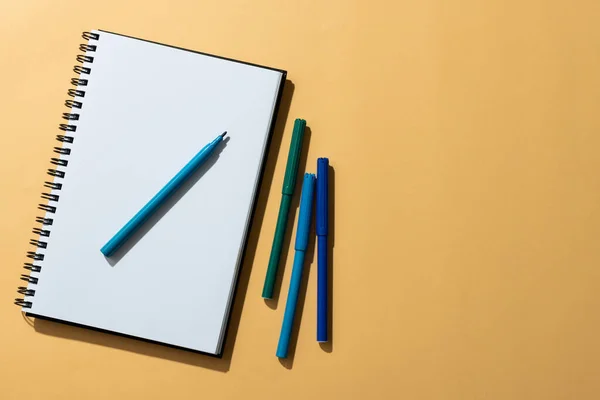 Close Van Notebook Vier Markers Met Kopieerruimte Oranje Achtergrond Schoolmaterialen — Stockfoto