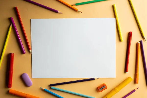 オレンジの背景にコピースペースとペンとマーカーと白い紙のフラットレイアウト 学校の教材 教育の概念 — ストック写真