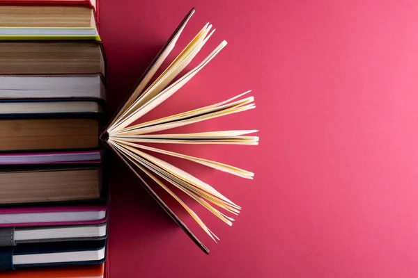 上に開いたノートブックと赤い背景にスペースをコピーして行に本やノートブック 教育の概念 — ストック写真