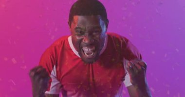 Afro-Amerikan futbolcunun üzerine düşen konfeti animasyonu. Spor, rekabet, kazanma ve kutlama konsepti dijital olarak oluşturulmuş video.