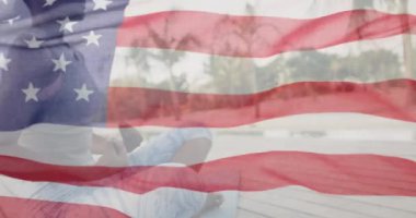 Afro-Amerikan kadının güneşli plajda meditasyon yaparken Amerikan bayrağını sallaması. Amerika, bağımsızlık, kutlama, gelenek, bayram ve vatanseverlik konsepti dijital olarak oluşturulmuş video.