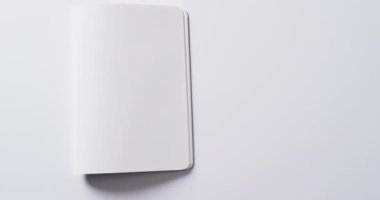 Beyaz arkaplan üzerine kopya alanı olan boş kitabı yavaş çekimde kapat. Edebiyat, okuma ve kitaplar.