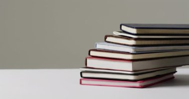 Gri arkaplanla ilgili kitapları yavaş çekimde kapat. Okuma, öğrenme, okul ve eğitim kavramı.