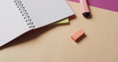 Bej ve mor arkaplan üzerine okul kırtasiyesi olan açık defteri yavaş çekimde kapat. Kırtasiye, öğrenim, okul ve eğitim kavramı.