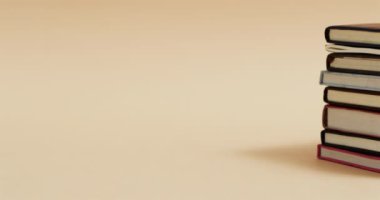 Bej arkaplan üzerine kopya alanı olan kitap yığınını yavaş çekimde kapat. Okuma, öğrenme, okul ve eğitim kavramı.