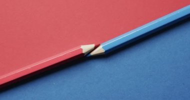 Mavi ve kırmızı pastel boyaların yukarıdan görünüşü kırmızı ve mavi arka planda, yavaş çekimde. Kırtasiye, öğrenim, okul ve eğitim kavramı.