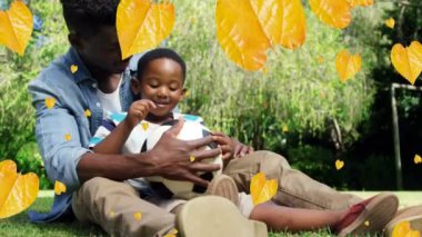 Afrika kökenli Amerikalı baba ve oğul üzerine düşen yaprakların animasyonu. Aile ve birlikte zaman geçirme kavramı dijital video üretimi.