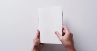 Yavaş çekimde, beyaz arka planda fotokopi alanının olduğu kitaptaki yaprakları kapatın. Edebiyat, okuma, boş zaman ve kitap.