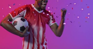 Afro-Amerikan futbolcunun üzerine düşen konfeti animasyonu. Spor, rekabet, kazanma ve kutlama konsepti dijital olarak oluşturulmuş video.