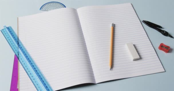 Großaufnahme Eines Offenen Notizbuchs Mit Schulpapier Auf Blauem Hintergrund Zeitlupe — Stockvideo