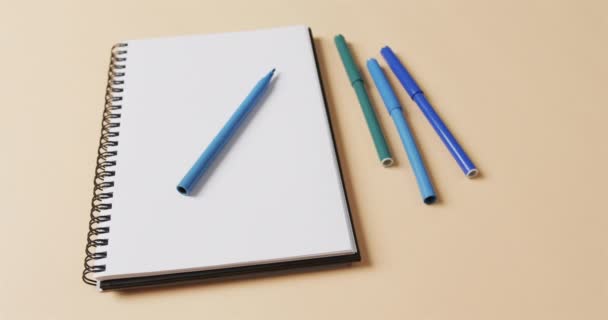 Primer Plano Los Marcadores Azules Con Cuaderno Sobre Fondo Beige — Vídeos de Stock