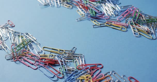 Close Scattered Colourful Paper Clips Copy Space Blue Background Slow — Stock Video