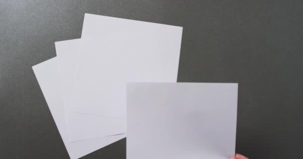 Zeitlupe Ein Blatt Papier Mit Kopierraum Auf Grauem Hintergrund Der — Stockvideo