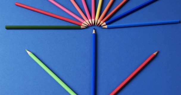 Primer Plano Crayones Dispuestos Sobre Fondo Azul Cámara Lenta Papelería — Vídeo de stock