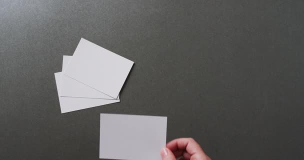 Рука Тримає Шматок Паперу Над Шматочками Паперу Копіювальним Простором Сірому — стокове відео