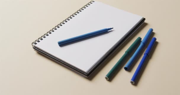 Primer Plano Del Cuaderno Con Marcadores Azules Sobre Fondo Beige — Vídeos de Stock