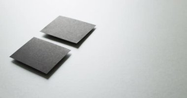 Gri arkaplandaki iki siyah kartviziti kapat. Kopyalama alanı, yavaş çekim. İş, iletişim detayları, modelleme, tasarım şablonu.