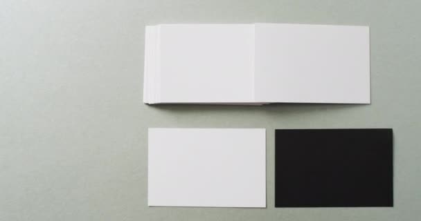 グレーの背景に空白の白と黒の名刺のオーバーヘッドビュー コピースペース スローモーション ビジネス 連絡先の詳細 モックアップ デザインのテンプレート — ストック動画