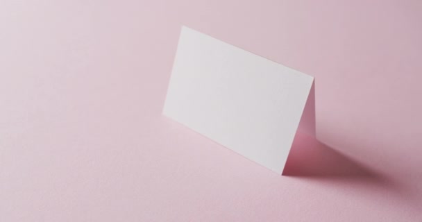 Close Van Twee Blanco Witte Visitekaartjes Roze Achtergrond Kopieerruimte Slow — Stockvideo